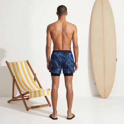 Coastal Wave Blue Swim Shorts rear view with surfboard